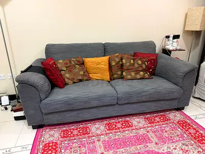Comfortable 3-seater grey fabric sofa with cushions