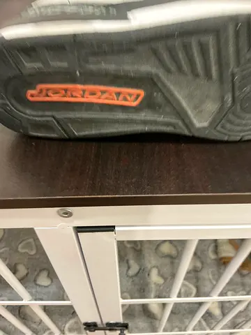 Used Nike kids sneakers, black/grey with orange logo, size unknown