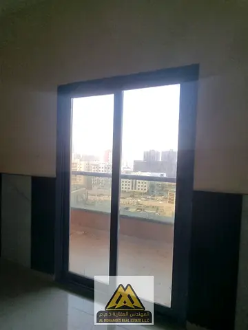 Large studio apartment with balcony and open view, free parking, in Al Nuaimiya 1 Tower C, near Al Hikma School and close to all services and roads.