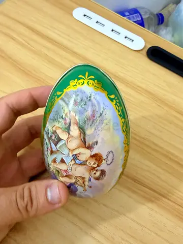 Hand-painted decorative porcelain egg with cherub scene