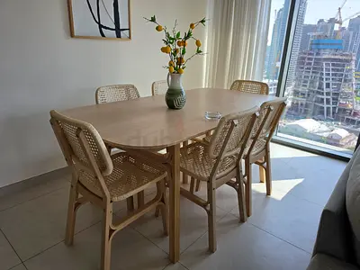Light wood dining table with 6 rattan-style chairs - good condition