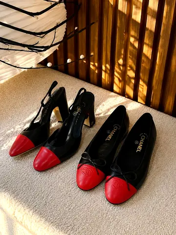 Pair of Chanel-inspired black leather flats and slingback heels with red cap toes