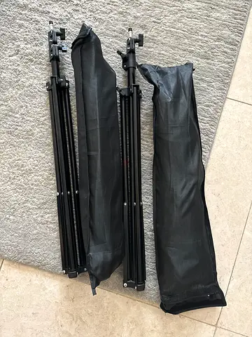 Two adjustable light stands / tripods with carrying bags