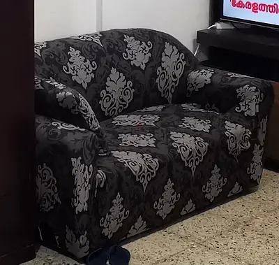 Two-seater patterned fabric sofa - good used condition with sofa cover.