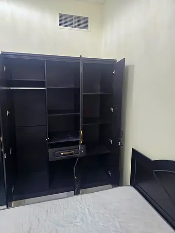 Dark wood 3-door wardrobe with multiple shelves and hanging rail - good condition