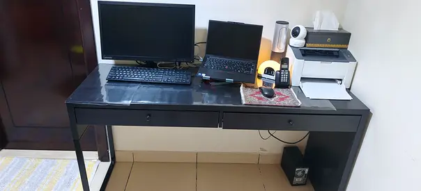 Ikea Black rectangular writing desk with drawers.