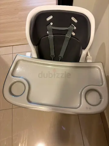 Baby high chair with removable feeding tray and safety harness.