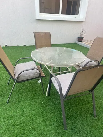 Outdoor glass-top patio table with 4 sling chairs - good condition