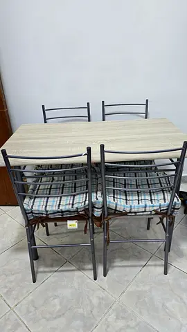 4-seater dining table with metal chairs and cushions