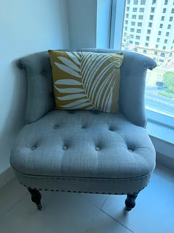 Light grey tufted accent armchair with nailhead trim