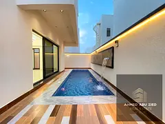 5 master bedrooms, a large living area, and a swimming pool featuring a luxurious wall-mounted water