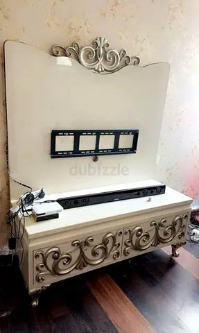 Ornate cream TV console with decorative back panel and storage