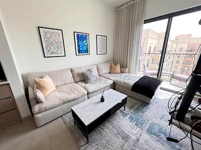 Light grey L-shaped fabric sofa with blanket and cushions