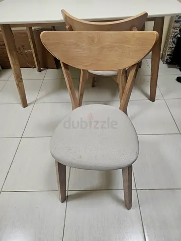 Set of 4 light wood dining chairs with padded cream seats