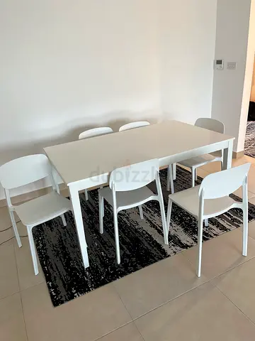 White dining table with 6 chairs and black patterned rug - good condition