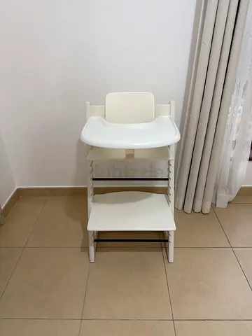 White wooden adjustable baby high chair with tray. STOKKE TRIPP TRAPP.