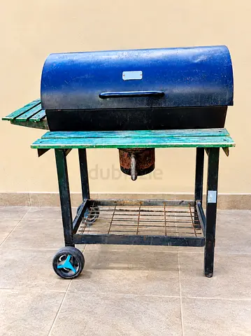 Used outdoor charcoal grill on trolley with side shelves