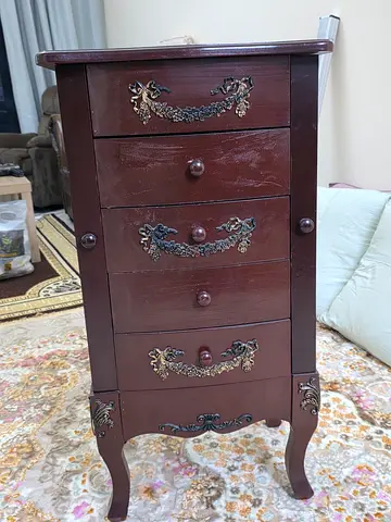 Vintage wooden bedside chest with ornate brass details