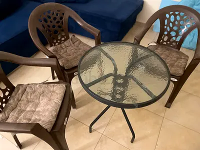 Outdoor plastic chairs (4) with small glass-top patio table