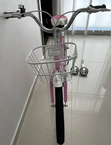 Kids pink bicycle with removable training wheels and front basket - good condition,