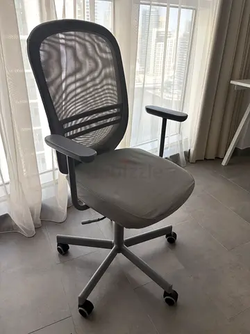 Ergonomic grey mesh office chair with adjustable arms and wheels in a very good condition