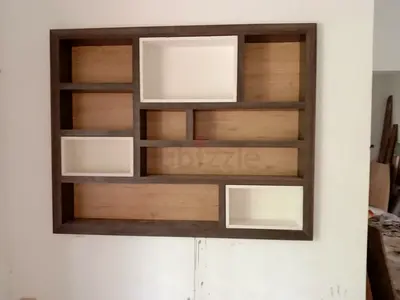 Wooden wall-mounted display shelf with white accent boxes