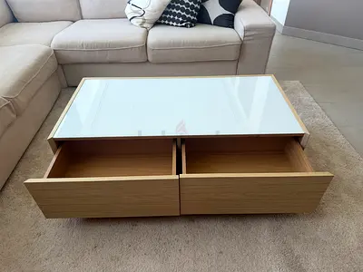 Wooden coffee table with glass top and two drawers