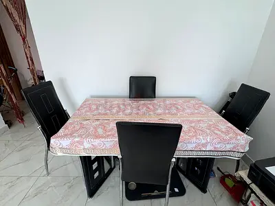 Modern Glass dining table with 4 black leather chairs - good condition