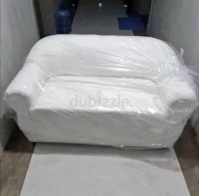 Two-seater white sofa wrapped in protective brand new