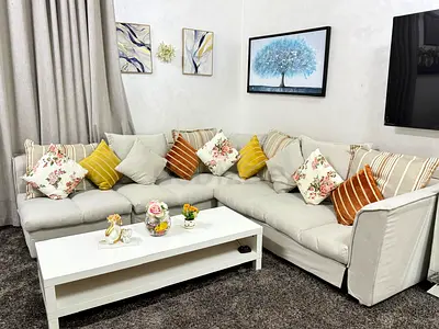 Light grey L-shaped fabric corner sofa with cushions