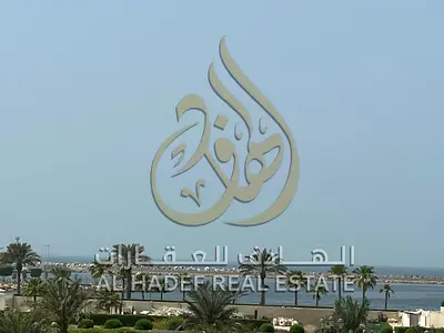 A three-bedroom apartment with a living room in Al-Qulai'a, featuring a sea view and a balcony. It