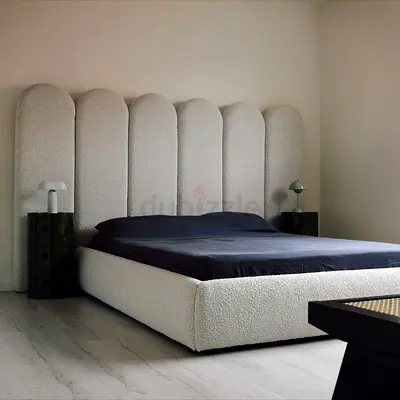 Modern upholstered platform bed with tall scalloped headboard