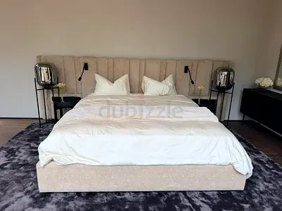Large upholstered king bed frame with tall channel-tufted headboard