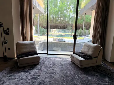 Pair of low-profile lounge chairs with large grey rug - good condition