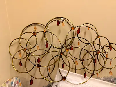 Metal circular wall art with amber and red glass drops