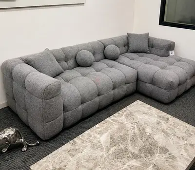 Light grey tufted L-shaped fabric sectional sofa
