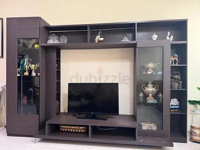 Dark wood TV entertainment center with glass display cabinets