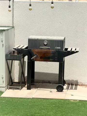 Used outdoor charcoal grill with side burner and storage