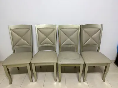 Set of 4 beige dining chairs — good condition with some pen marks on the surface.