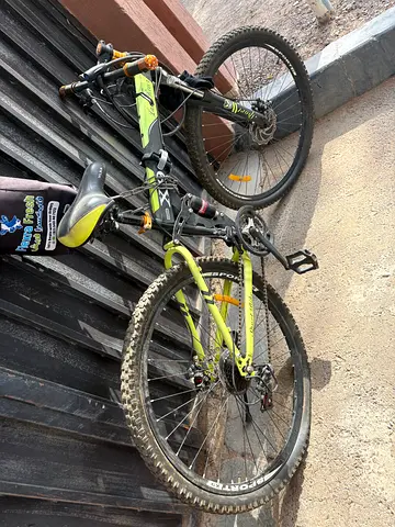 Used full-suspension mountain bike - 26", green/black, it’s in good condition but back side puncture