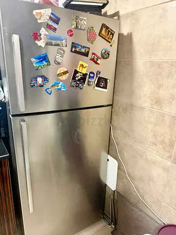 Hoover fridge freezer in like-new condition, with a silver finish and a separate top freezer compart