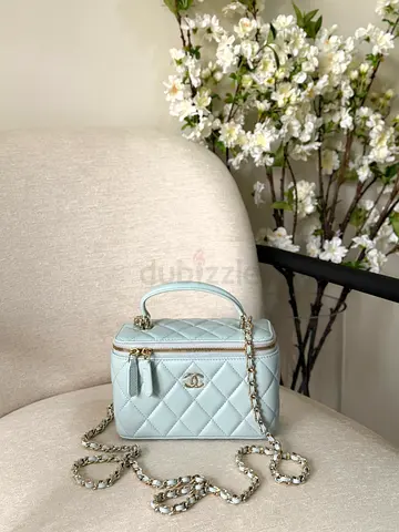 Light blue quilted Chanel-style vanity bag with chain strap