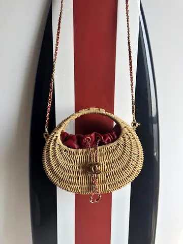 Woven straw shoulder bag with chain strap and burgundy lining