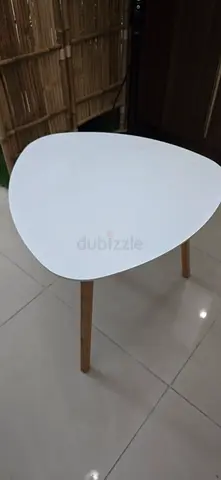 Small white triangular side table with wooden legs