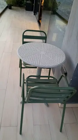Outdoor bistro set — round metal table with two green chairs