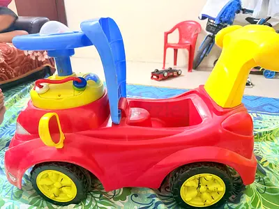 Red plastic ride-on car for toddlers - good condition