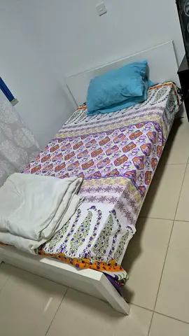 Single wooden bed frame with mattress and bedding