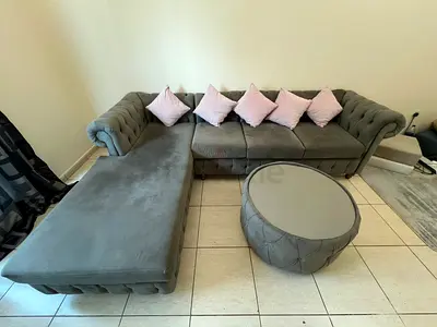 L-shaped grey velvet Chesterfield sofa with ottoman