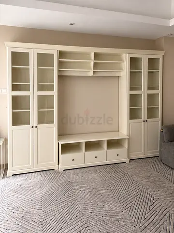 White wooden entertainment center with glass cabinets and storage