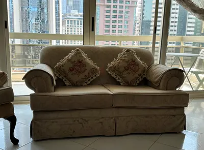 Two-seater beige patterned sofa with cushions - good condition